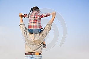 Father carrying his daughter on shoulders