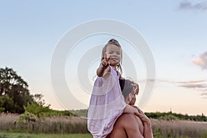 Father carrying his little daughter on shoulders with blue sky background. Happy loving family. Father and daughter