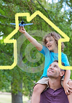 Father carrying son on his shoulders overlaid with house shape