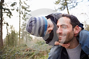 Father Carrying Son On Shoulders During Countryside Walk