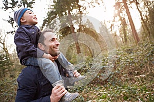 Father Carrying Son On Shoulders During Countryside Walk