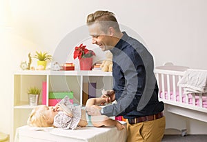 Father changing baby girl diapers