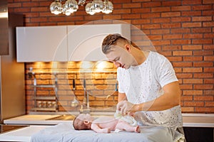 Father is changing nappy to his baby boy