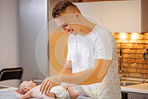 Father is changing nappy to his baby boy