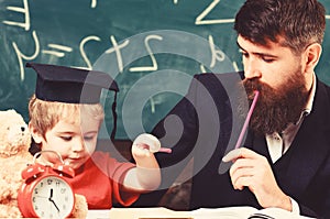 Father checking hometask, helps to boy, son. Hometask concept. Enthusiastic kid studying with teacher. Teacher in formal photo