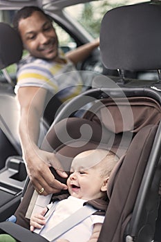Father cheering baby up while in the car