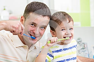 Father and child brushing teeth in bathroom