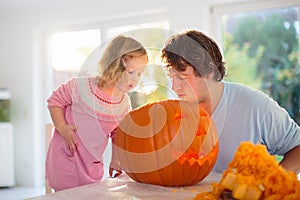 Father and child carving pumpkin for Halloween