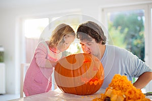 Father and child carving pumpkin for Halloween