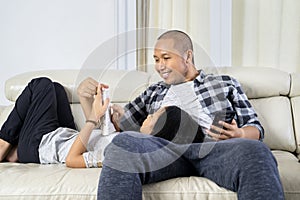 Father and child enjoying leisure time on couch