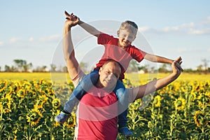 Father with child in a field of blooming sunflowers