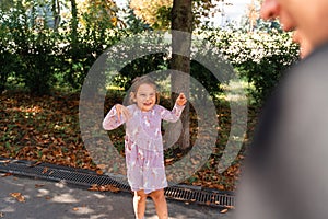 Father and child girl playing Tag chasing game outdoors on the streets. Quality time with kids, modern parenthood