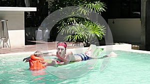 Father and child are having fun in swimming pool. Dad and son are indoor pool. Father teach son to swim. Concept of kids