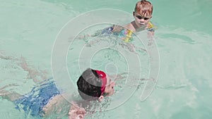 Father and child are having fun in swimming pool. Dad and son are indoor pool. Father teach son to swim. Concept of kids