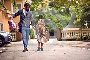 Father and child holding hands going to school