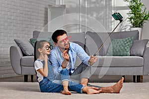 father and child holding paper glasses on stick and take a selfie