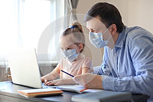 Father and child at home doing online school teaching class. Distance learning in epidemic of COVID-19