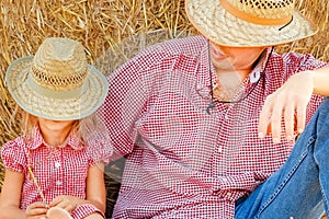 A father with a child near a haystack on a ranch field. Happy people on nature background