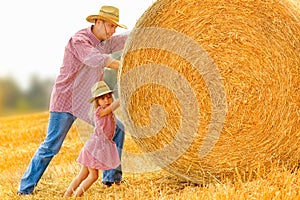 Father with a child play kittens a haystack on the field. Happy family work hard at the ranch