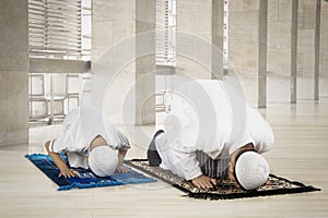 Father and child posing prostration in the mosque