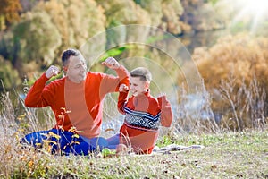 father and child reading the Bible on nature