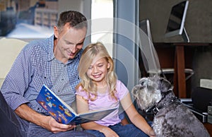 Father, child and reading book for learning at home, story and fantasy fiction for education. Daddy, daughter and dog