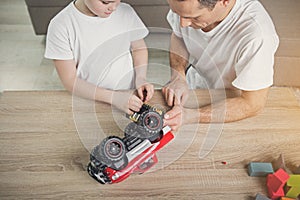 Father and child repairing toy vehicle