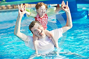 Father and child in resort swimming pool