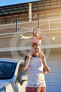 Father, child and shoulders in yard for portrait, happy and soap with sponge for washing family car. Dad, girl and