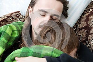 Father and child sleeping home together on armchair. Family resting. Happy parenthood, fatherhood. Dad and daughter