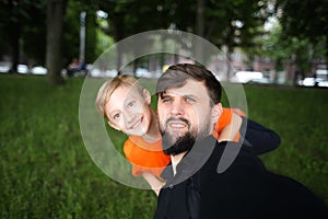 Father and the child take a selfie look at the camera and laugh merrily the child is standing behind