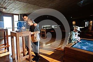 Father with children exploring expositions in museum halls