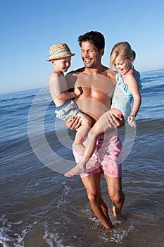 Father And Children Having Fun On Beach