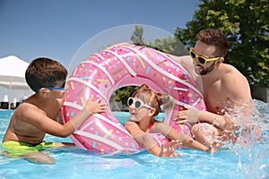 Father and children having fun in pool. Family vacation