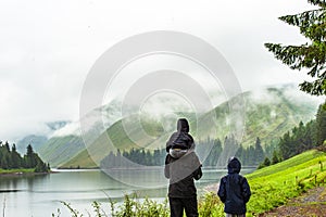 Father with children hiking along beautlful lake with hills cove