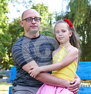 Father with children in park, happy family portrait, two peoples sit on bench, parenting concept