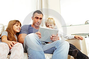 Father with children playing on tablet computer
