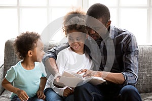 Father with children read a book at home