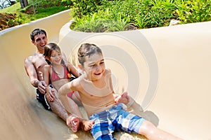 Father and Children Sliding Down Water Slide