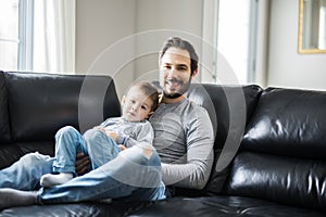 Father And Children On Sofa At Home Watching TV Together