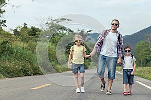 Father and children walking on the road at the day time