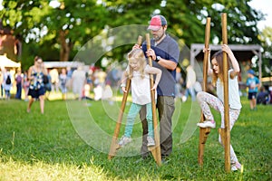 Father and children walking on stilts during annual Medieval Festival, held in Trakai Peninsular Castle