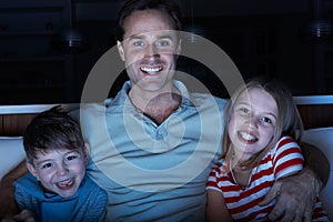 Father And Children Watching Programme On TV Tog photo