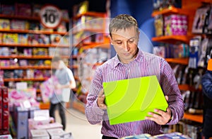 Father choosing playthings for child in toy store