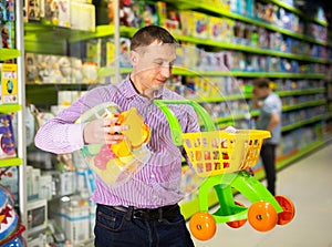 Father choosing playthings in toy store