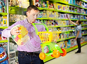 Father choosing playthings in toy store