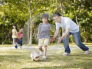 Father coaching son to play soccer