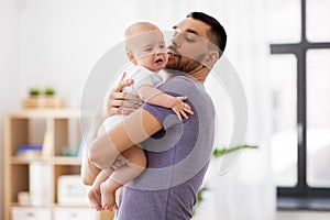 Father with crying little baby at home