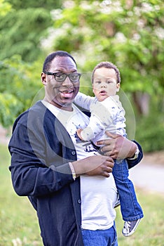 Father cuddling adorable biracial baby boy