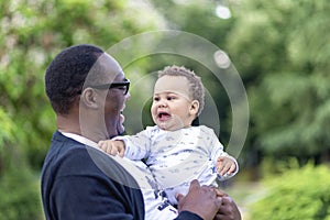 Father cuddling adorable biracial baby boy